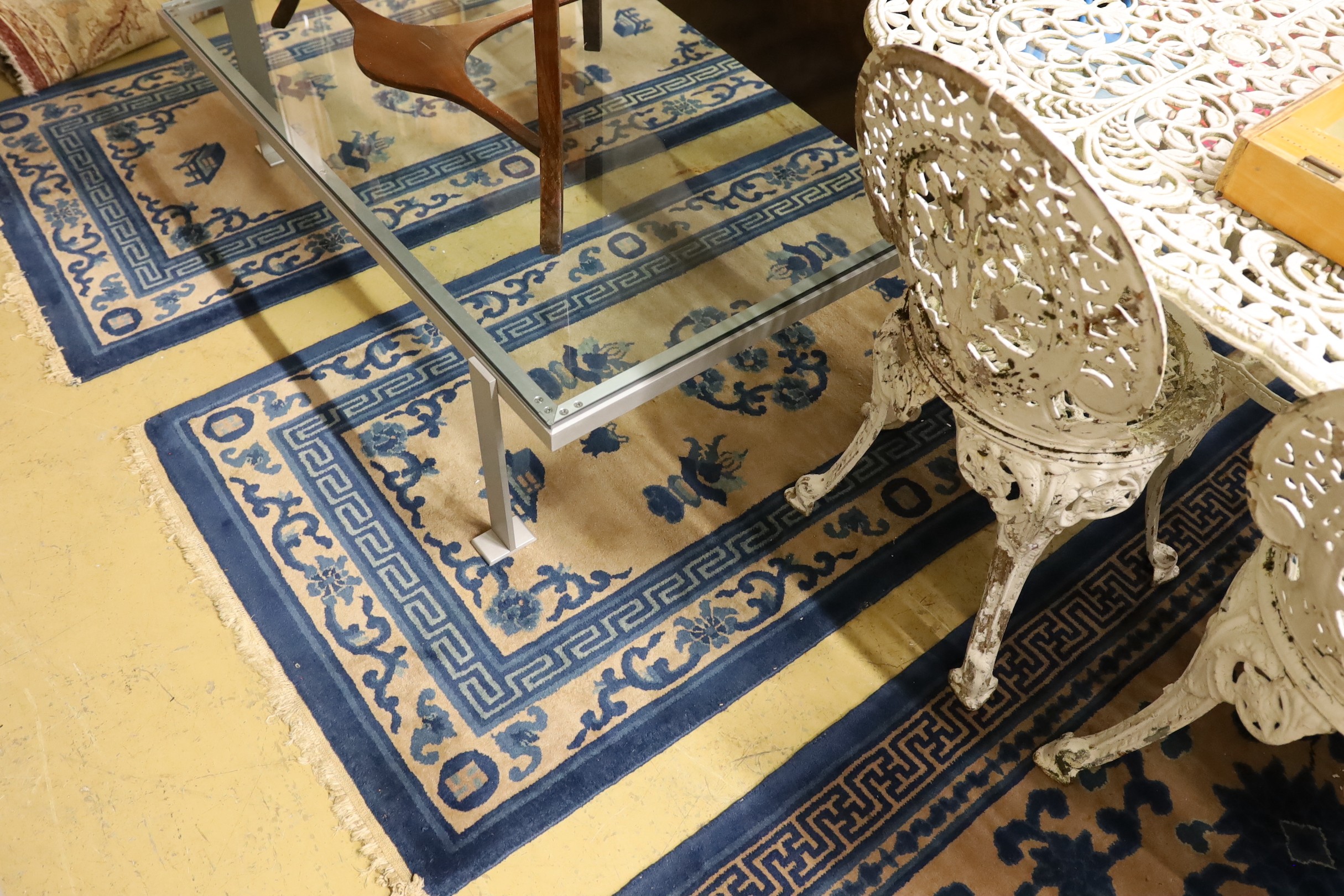 A pair of Chinese beige ground rugs and a similar rug, 174 x 92cm
